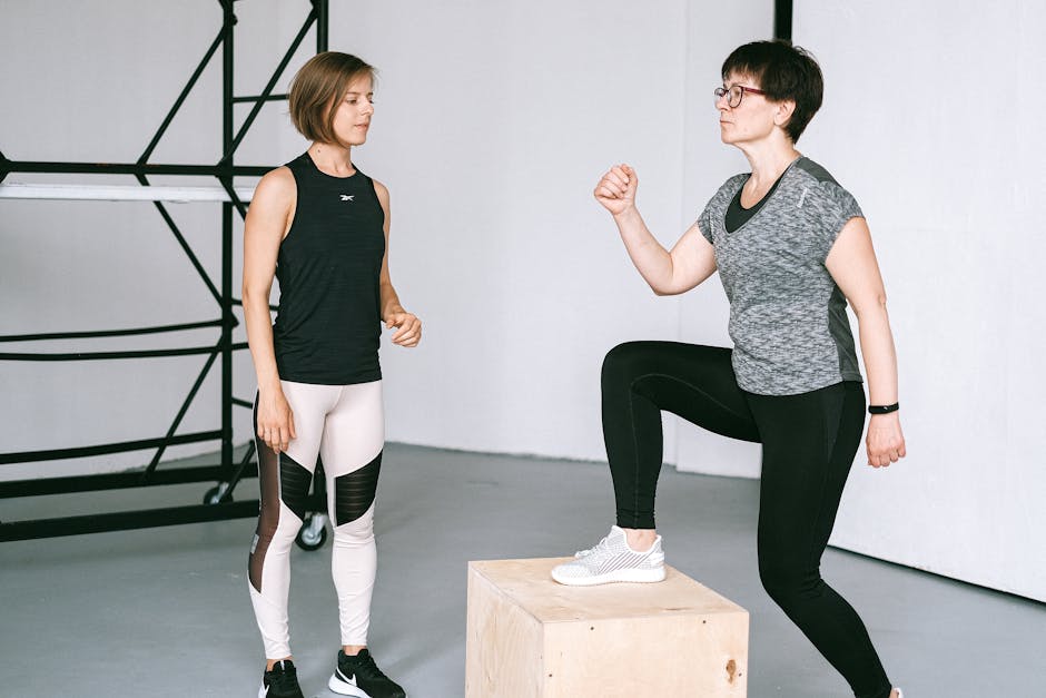Fitness coach guides a woman in workout indoors. Focus on exercise and healthy lifestyle.